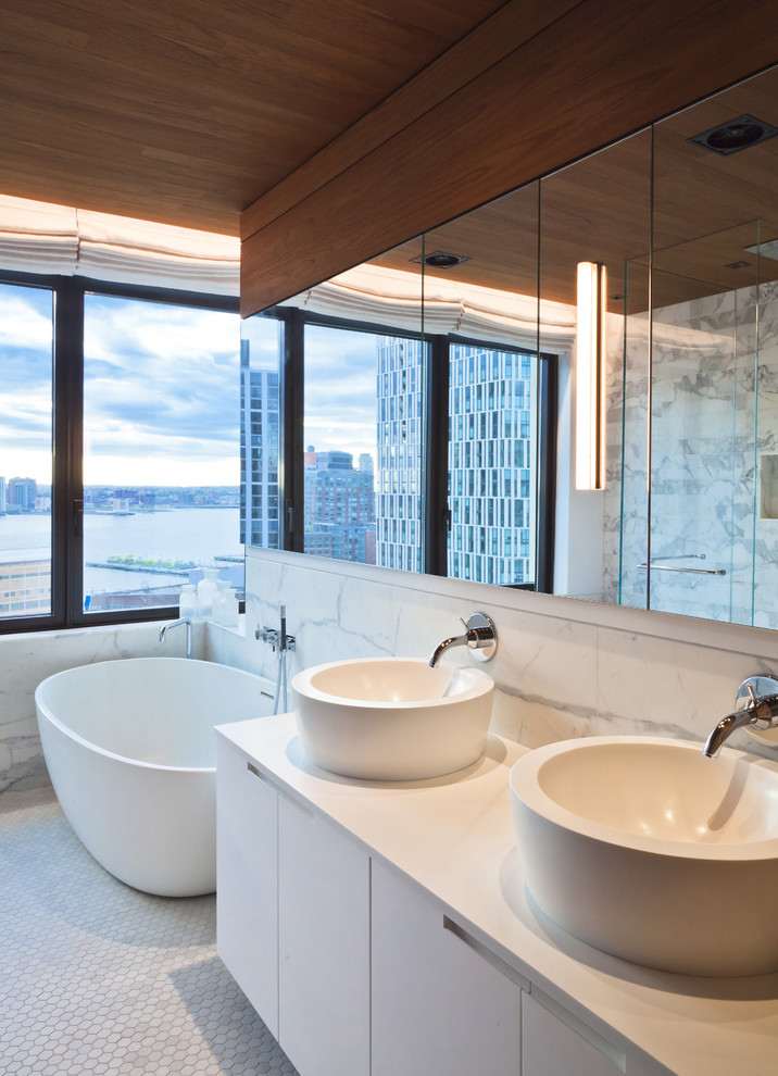 Стильный дизайн: ванная комната: освещение в стиле модернизм с отдельно стоящей ванной и настольной раковиной - последний тренд