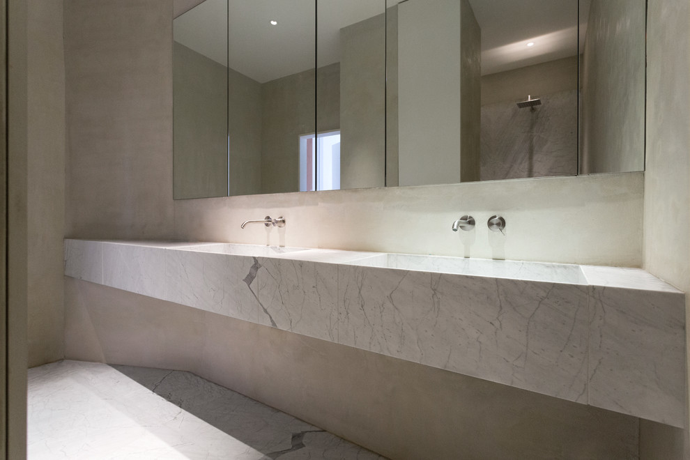 Modern inredning av ett mellanstort badrum med dusch, med vita skåp, en dubbeldusch, vit kakel, stenhäll, beige väggar, marmorgolv och marmorbänkskiva