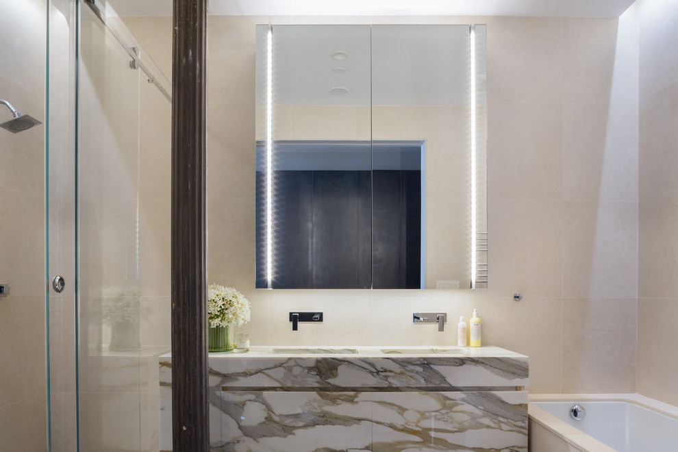 Modern inredning av ett mellanstort en-suite badrum, med släta luckor, ett platsbyggt badkar, en dubbeldusch, beige kakel, porslinskakel, beige väggar, klinkergolv i porslin, ett integrerad handfat och marmorbänkskiva