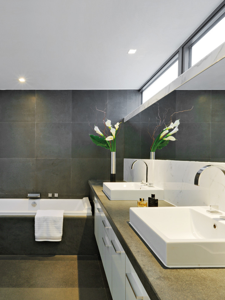 Idee per una grande stanza da bagno padronale minimalista con ante lisce, ante bianche, vasca da incasso, lavabo da incasso, top in cemento e top grigio
