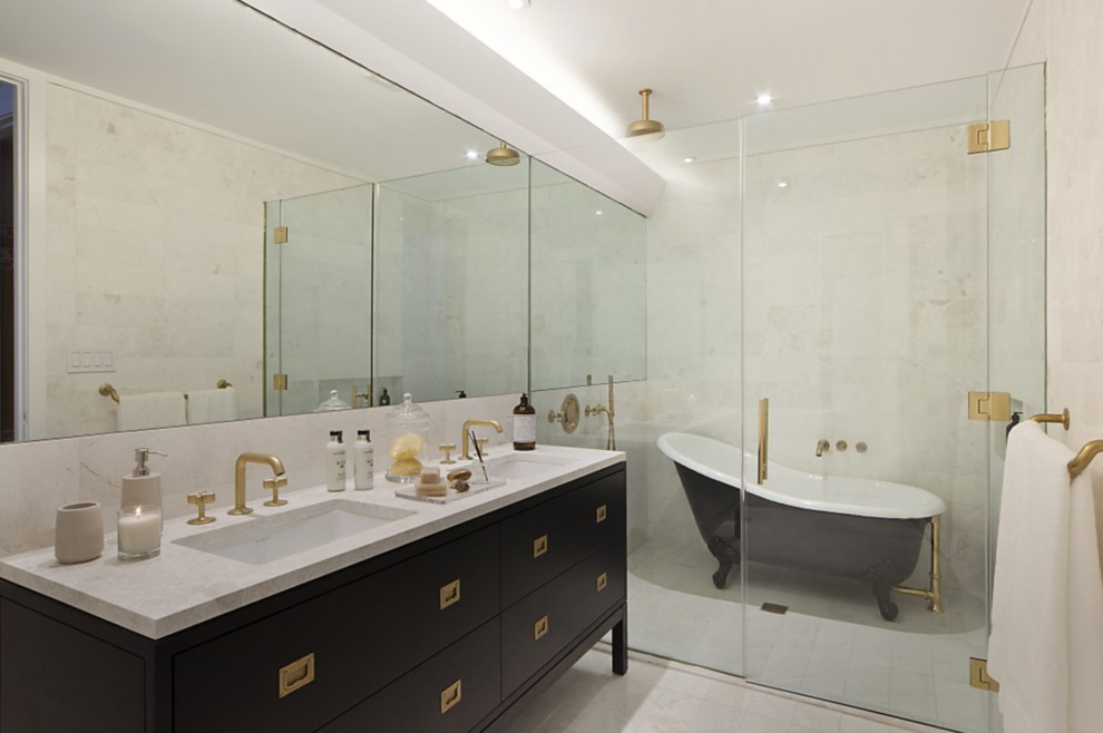 Inredning av ett klassiskt mellanstort en-suite badrum, med släta luckor, svarta skåp, ett badkar med tassar, en kantlös dusch, beige kakel, stenkakel, vita väggar, kalkstensgolv, ett undermonterad handfat och bänkskiva i kalksten