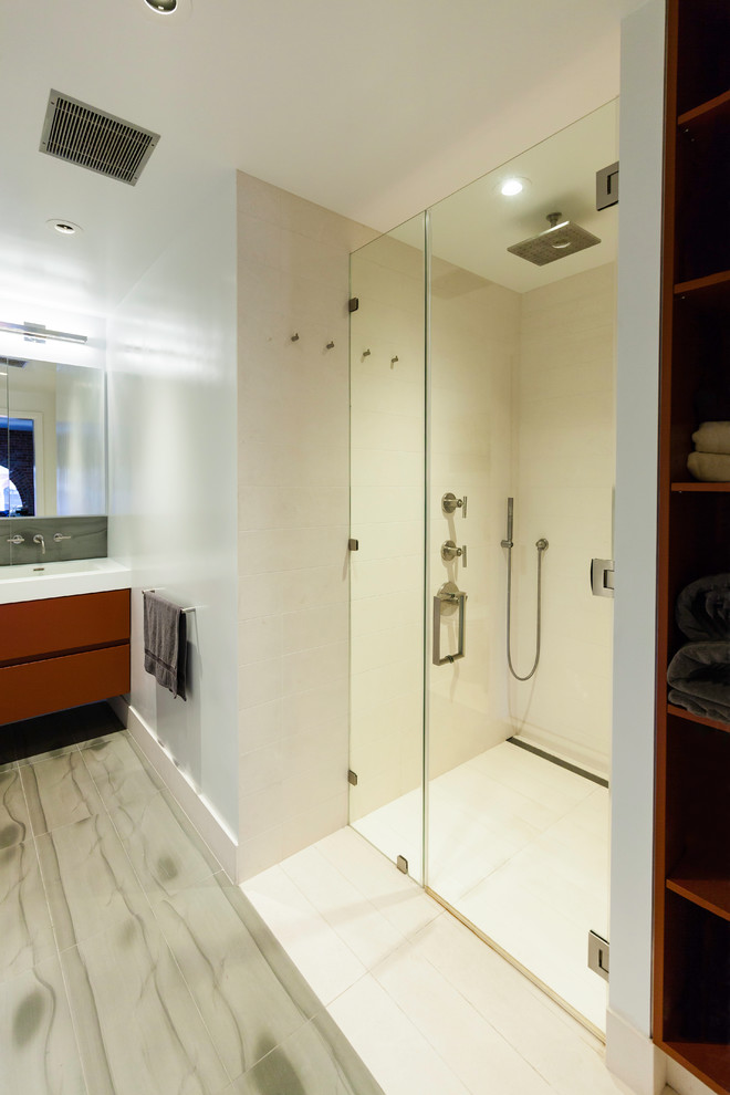 Diseño de cuarto de baño contemporáneo con armarios tipo mueble, puertas de armario rojas, ducha a ras de suelo, sanitario de pared, baldosas y/o azulejos grises, baldosas y/o azulejos de piedra, paredes blancas, lavabo integrado y encimera de acrílico