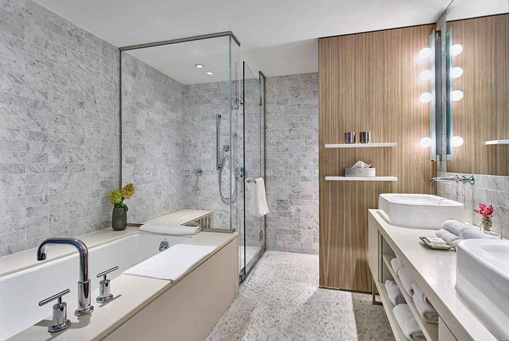 Aménagement d'une salle de bain contemporaine avec un placard sans porte, des portes de placard blanches, une baignoire encastrée, une douche d'angle, un carrelage gris, une vasque et une cabine de douche à porte battante.
