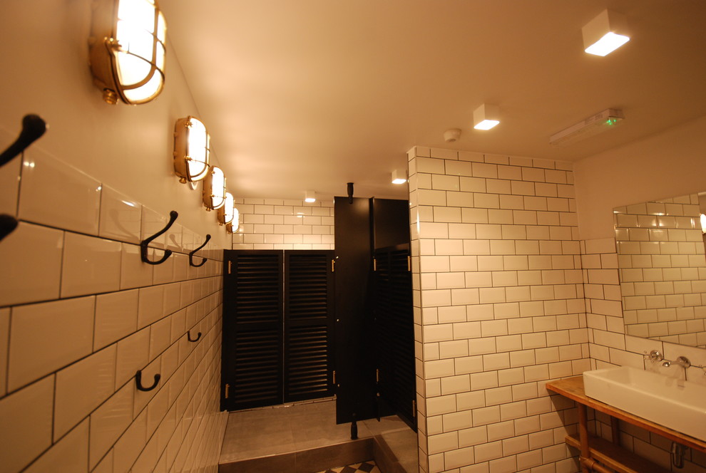 Ispirazione per una stanza da bagno minimalista di medie dimensioni con doccia a filo pavimento, piastrelle bianche, piastrelle di cemento, pareti bianche, pavimento in vinile, lavabo a consolle e top in legno