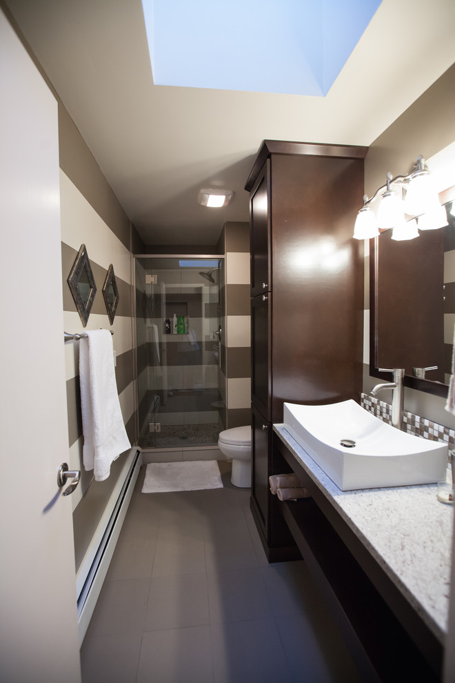 This is an example of a small bohemian shower room bathroom in Seattle with a vessel sink, flat-panel cabinets, dark wood cabinets, granite worktops, an alcove shower, a two-piece toilet, multi-coloured tiles, ceramic tiles, multi-coloured walls, ceramic flooring, grey floors, a hinged door and grey worktops.