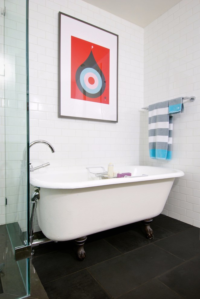 Foto på ett funkis badrum, med ett badkar med tassar och svart golv