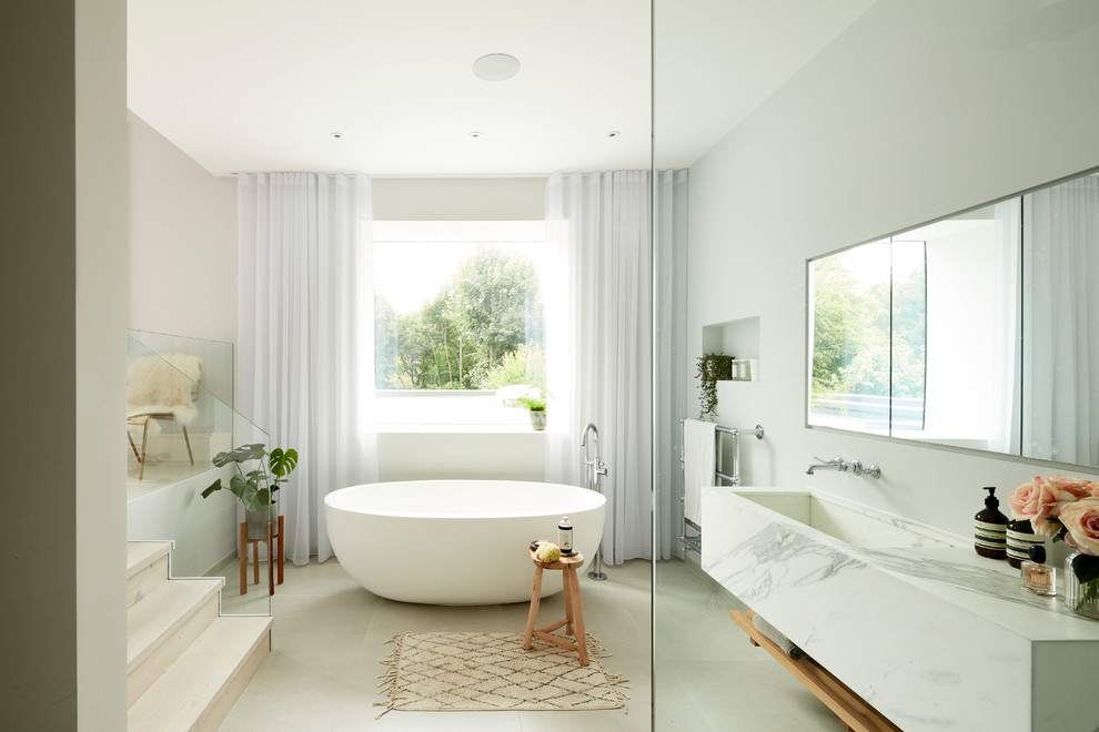 Aménagement d'une salle de bain principale contemporaine avec une baignoire indépendante, un mur gris, un lavabo encastré, une douche ouverte, un plan de toilette en marbre et aucune cabine.