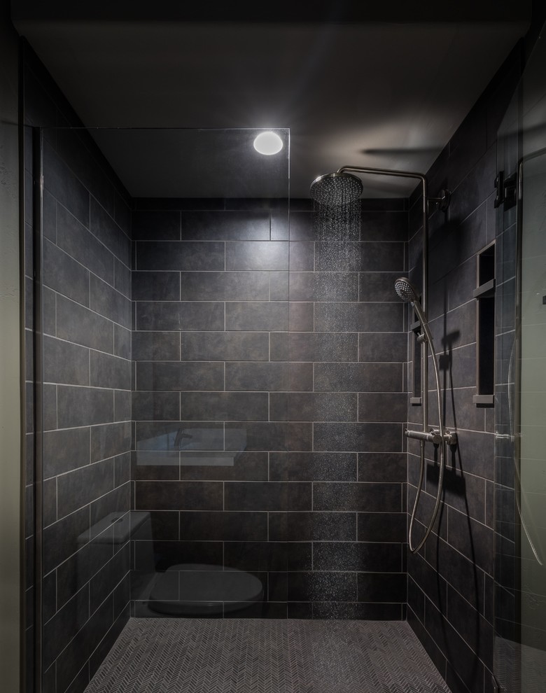 Mid-sized trendy 3/4 black tile and ceramic tile ceramic tile and beige floor tub/shower combo photo in Denver with flat-panel cabinets, medium tone wood cabinets, a one-piece toilet, gray walls, an undermount sink, quartz countertops and a hinged shower door