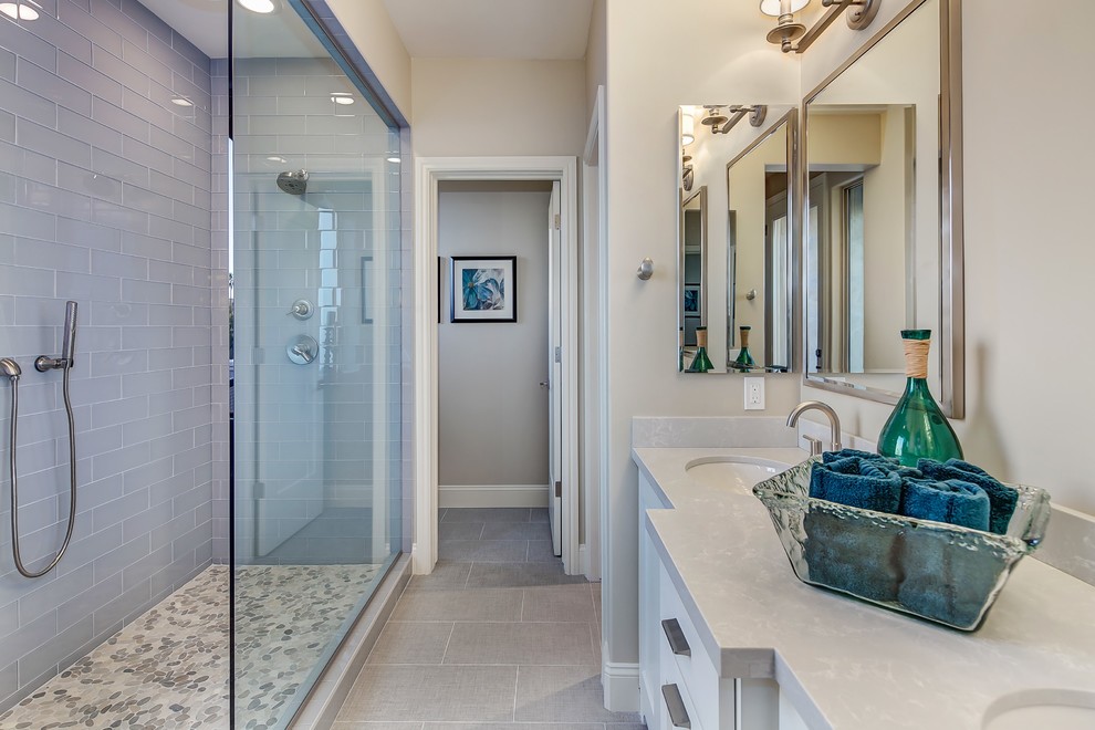 Exempel på ett mellanstort modernt en-suite badrum, med luckor med upphöjd panel, vita skåp, en dubbeldusch, en toalettstol med hel cisternkåpa, grå kakel, keramikplattor, grå väggar, klinkergolv i småsten, ett undermonterad handfat och bänkskiva i kvarts