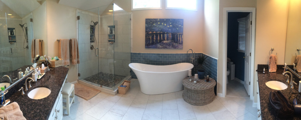 This is an example of a large mediterranean ensuite bathroom in Charlotte with raised-panel cabinets, white cabinets, a freestanding bath, a corner shower, a two-piece toilet, beige tiles, ceramic flooring, a submerged sink, granite worktops, white floors and a hinged door.