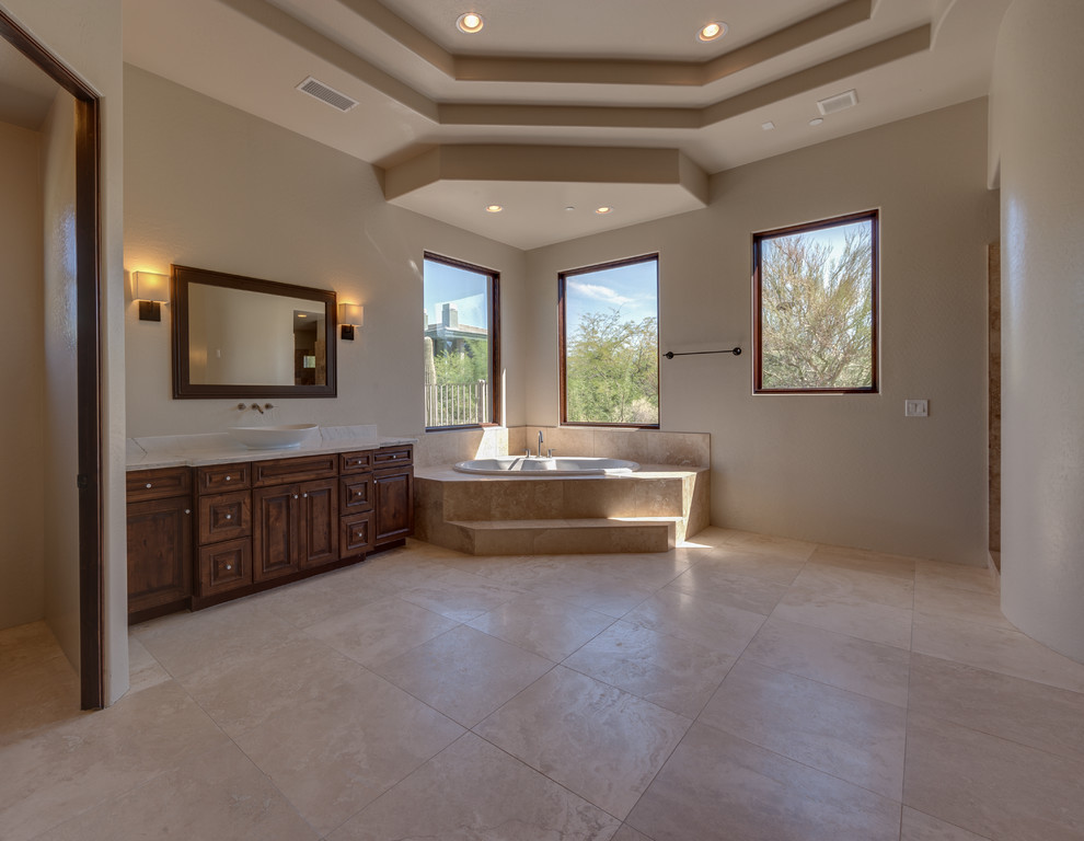 Inspiration for a large mediterranean master beige tile porcelain tile bathroom remodel in Phoenix with dark wood cabinets, granite countertops and beige walls