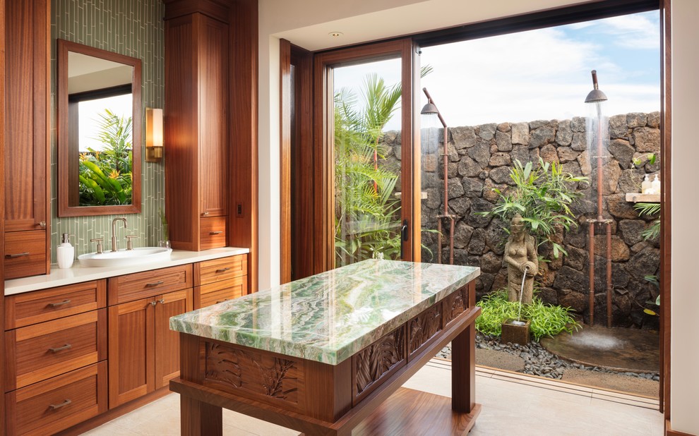 ハワイにあるトロピカルスタイルのおしゃれな浴室 (シェーカースタイル扉のキャビネット、中間色木目調キャビネット、ダブルシャワー、緑のタイル、白い壁、オーバーカウンターシンク、ベージュの床、引戸のシャワー、グリーンの洗面カウンター) の写真