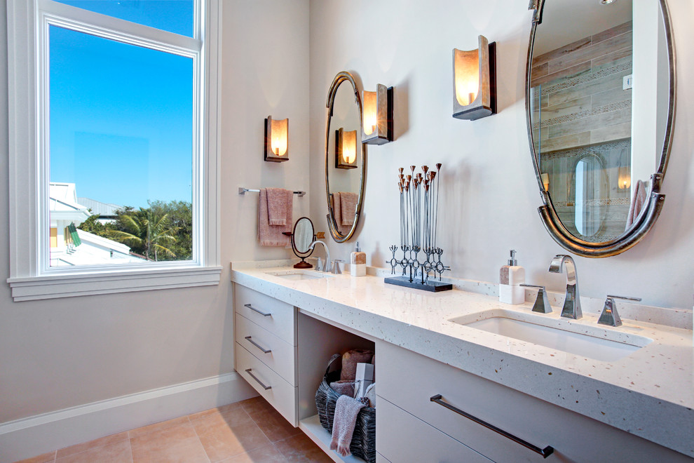 Diseño de cuarto de baño exótico con armarios con paneles lisos, puertas de armario beige, paredes beige, lavabo bajoencimera y espejo con luz