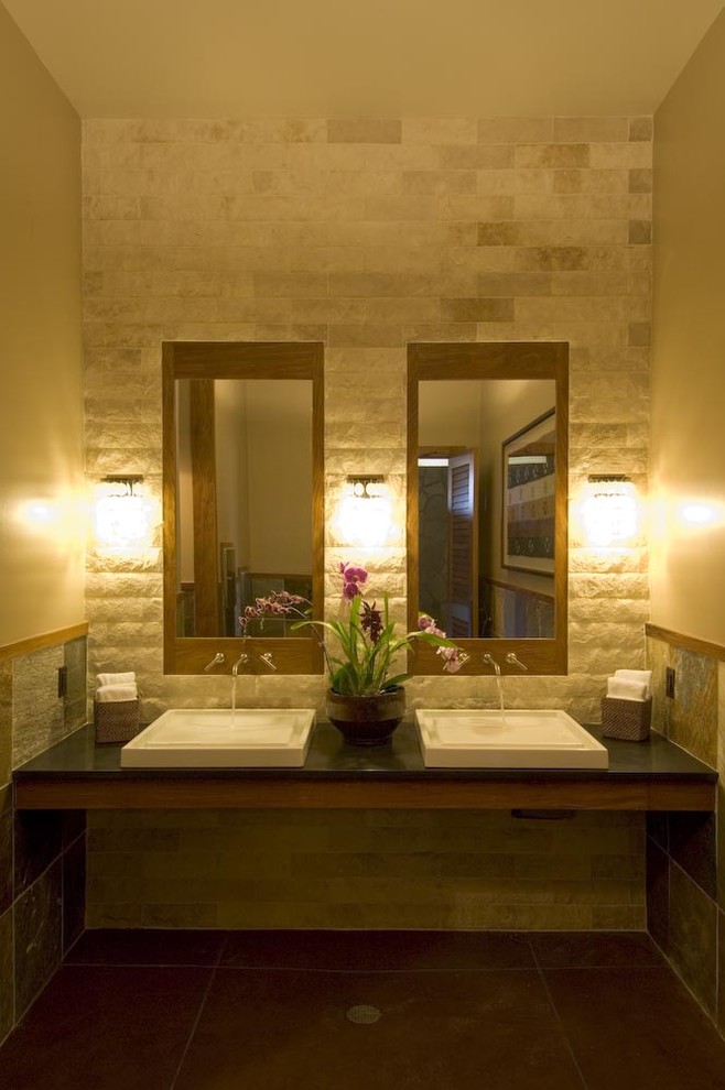 Modelo de cuarto de baño tropical con lavabo sobreencimera, baldosas y/o azulejos beige y piedra