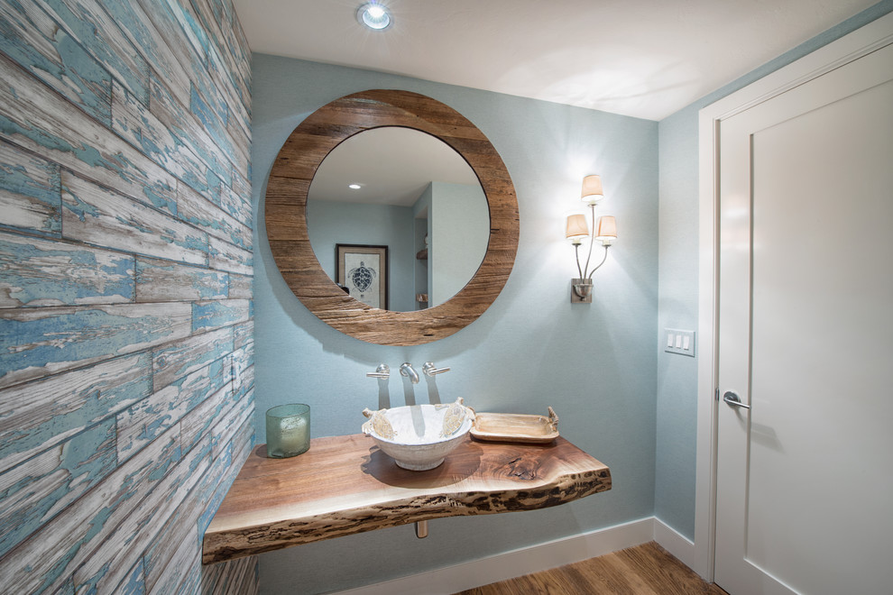 Kleines Duschbad mit blauer Wandfarbe, braunem Holzboden, Waschtisch aus Holz, Eckdusche, Toilette mit Aufsatzspülkasten, Sockelwaschbecken und braunem Boden in Miami