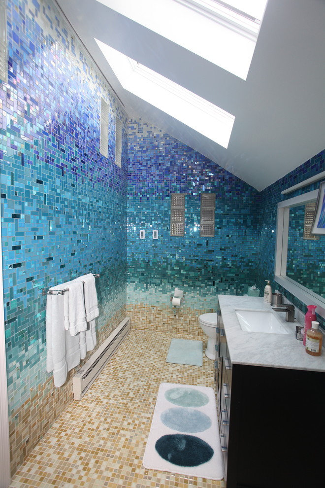 Inspiration pour une grande salle de bain principale ethnique avec un placard à porte plane, des portes de placard noires, une baignoire posée, une douche ouverte, WC à poser, un carrelage bleu, un carrelage en pâte de verre, un mur bleu, un sol en carrelage de céramique, un lavabo de ferme, un plan de toilette en surface solide, un sol beige et aucune cabine.