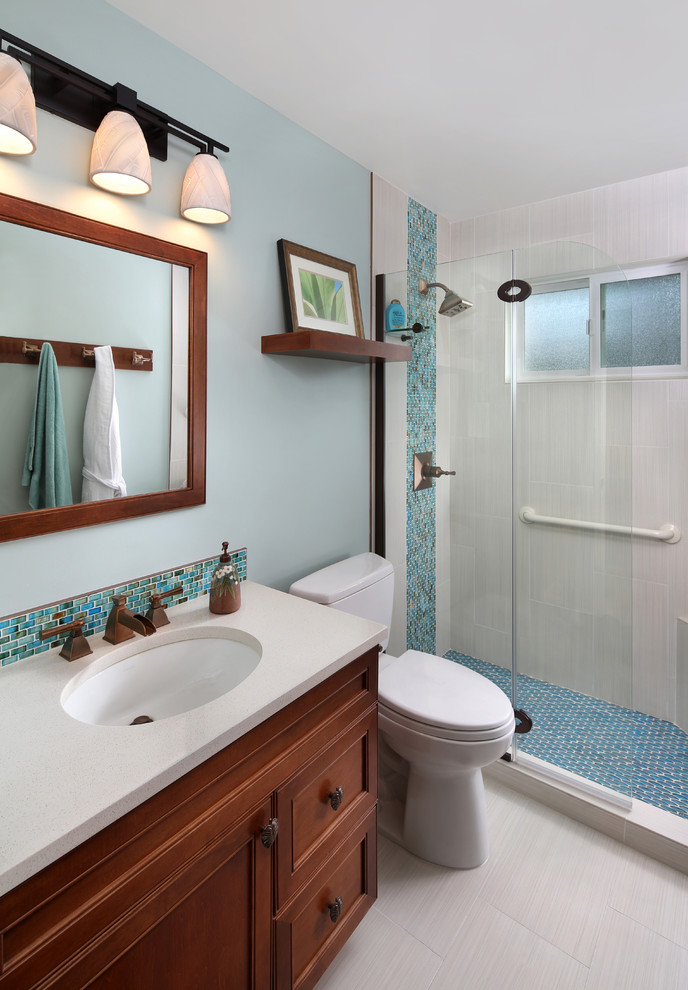 Idéer för att renovera ett litet tropiskt badrum, med ett undermonterad handfat, luckor med infälld panel, skåp i mellenmörkt trä, bänkskiva i kvarts, en dusch i en alkov, blå väggar och klinkergolv i porslin