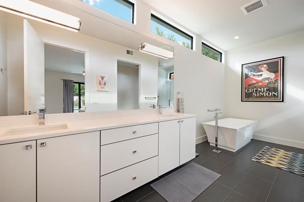 Modern inredning av ett mellanstort en-suite badrum, med släta luckor, vita skåp, bänkskiva i kvartsit, ett fristående badkar, en dusch i en alkov, grå kakel, keramikplattor, klinkergolv i keramik och ett undermonterad handfat