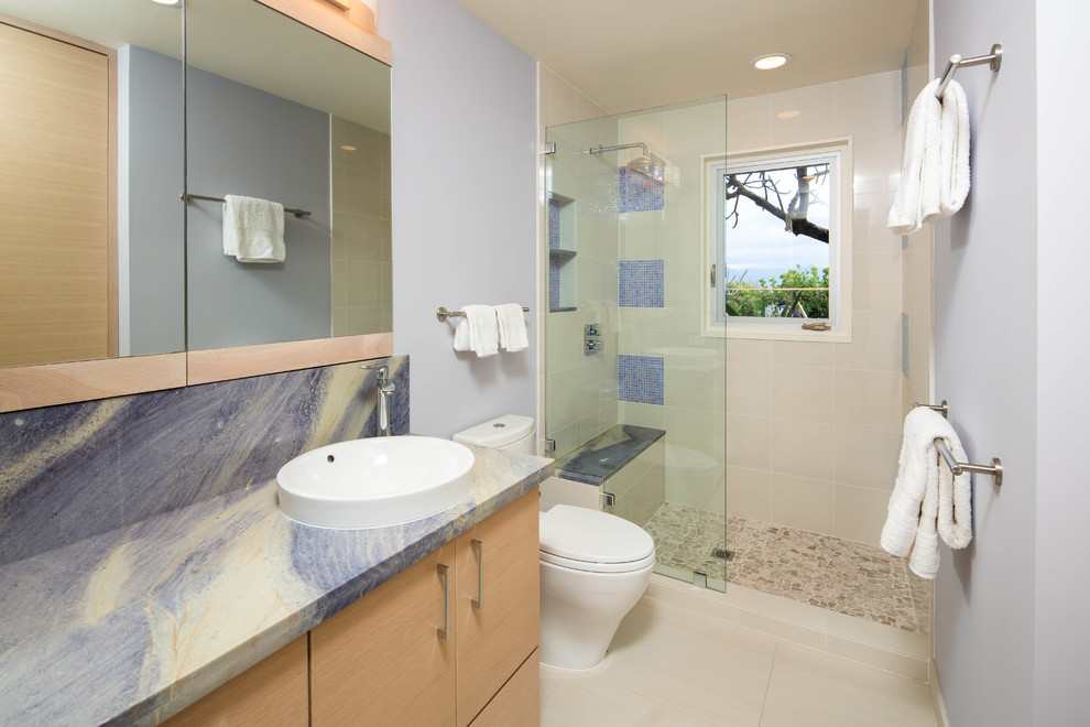 Example of a mid-sized 1960s kids' blue tile doorless shower design in Hawaii with flat-panel cabinets, light wood cabinets, a one-piece toilet, blue walls, a drop-in sink and marble countertops