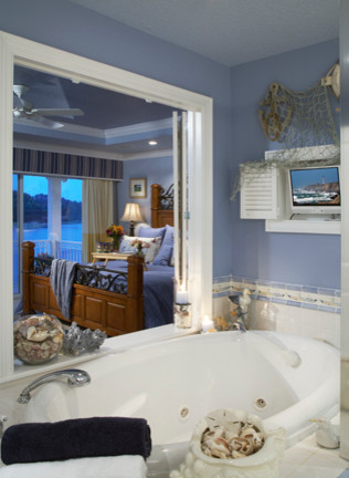 Ejemplo de cuarto de baño principal tradicional de tamaño medio con bañera encastrada, baldosas y/o azulejos blancos, baldosas y/o azulejos de vidrio y paredes azules
