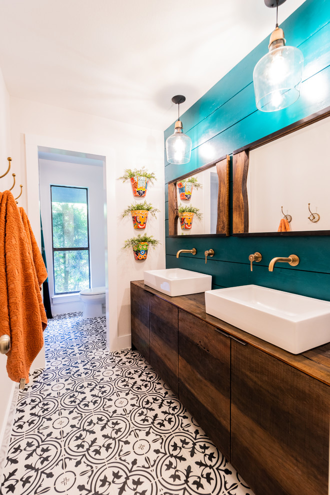 На фото: ванная комната в морском стиле с плоскими фасадами, фасадами цвета дерева среднего тона, синими стенами, полом из мозаичной плитки, настольной раковиной, столешницей из дерева, разноцветным полом и коричневой столешницей с
