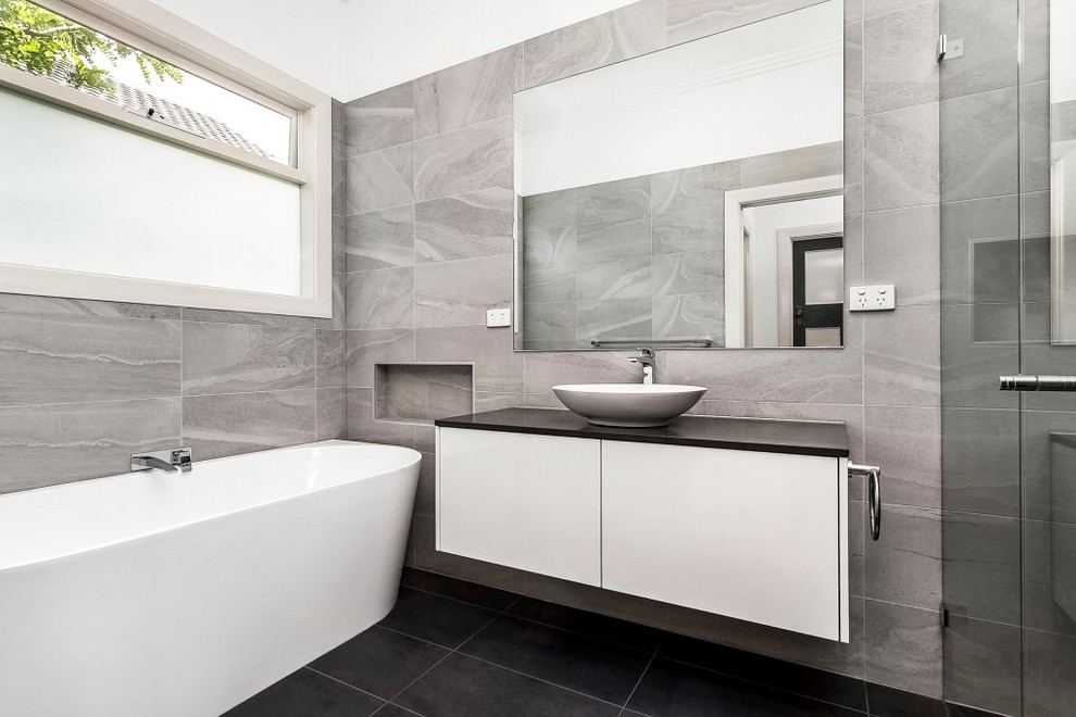Esempio di un'ampia stanza da bagno con doccia tropicale con piastrelle grigie