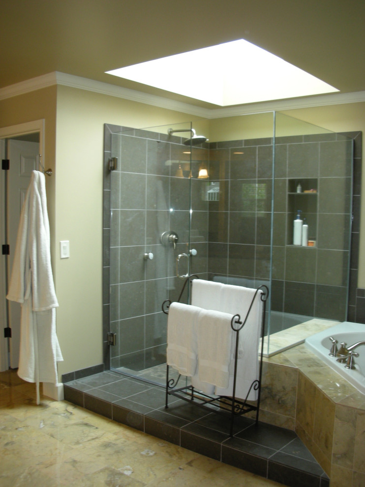 Inspiration for a large classic ensuite bathroom in Seattle with raised-panel cabinets, white cabinets, a built-in bath, a corner shower, a one-piece toilet, grey tiles, stone tiles, yellow walls, travertine flooring, a submerged sink, limestone worktops, yellow floors, a hinged door and grey worktops.