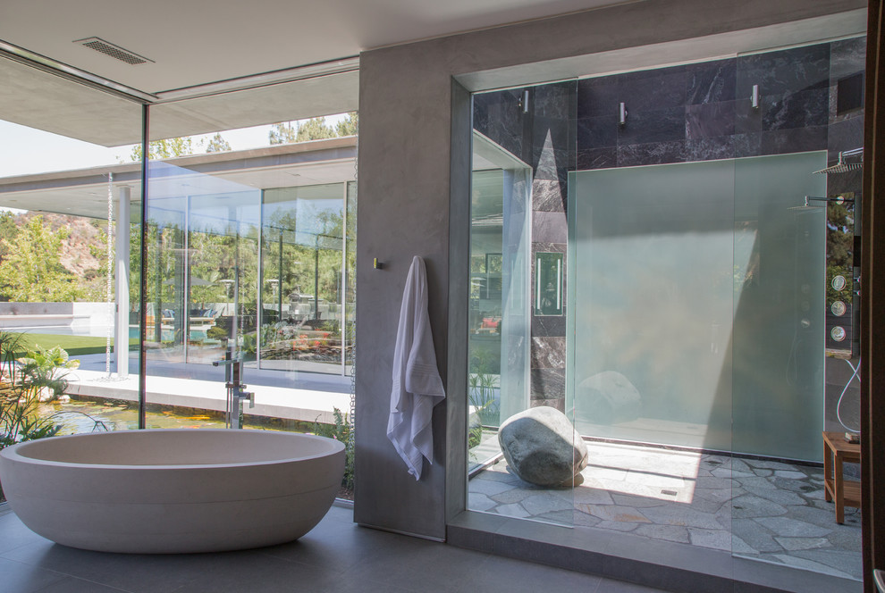 Idéer för ett mellanstort modernt en-suite badrum, med ett fristående badkar, en dusch i en alkov, betonggolv, grått golv och dusch med skjutdörr