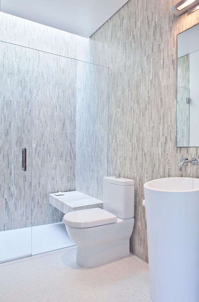Foto på ett funkis badrum, med ett piedestal handfat, en kantlös dusch, en toalettstol med separat cisternkåpa och grå kakel