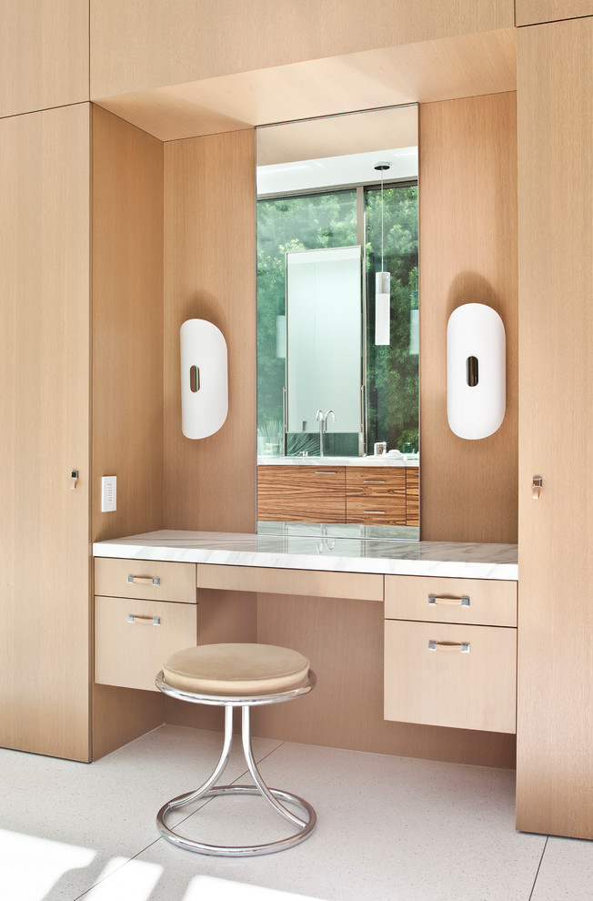 Immagine di una stanza da bagno contemporanea con ante lisce e ante in legno chiaro