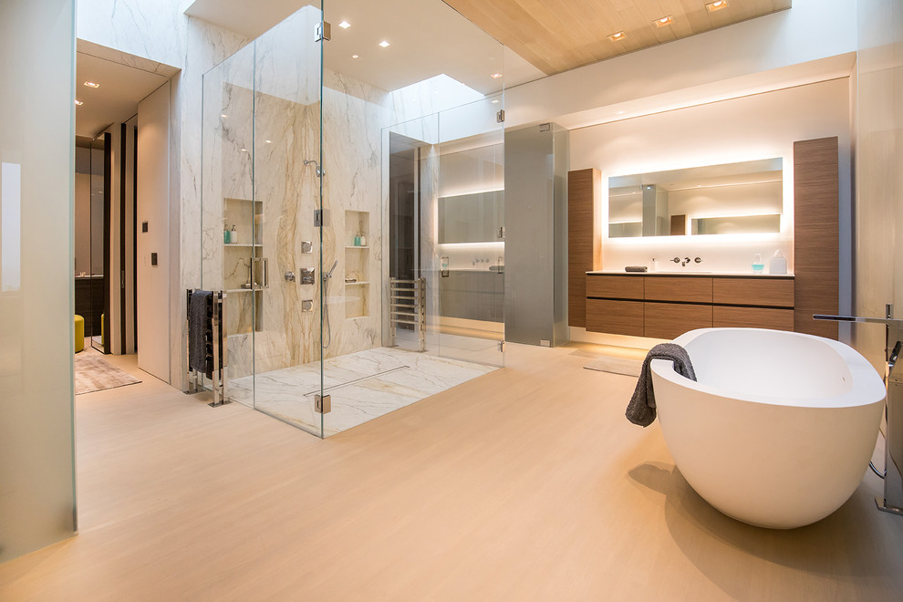 Foto på ett stort funkis en-suite badrum, med luckor med profilerade fronter, ett fristående badkar, en kantlös dusch, vit kakel, vita väggar, beiget golv och dusch med gångjärnsdörr