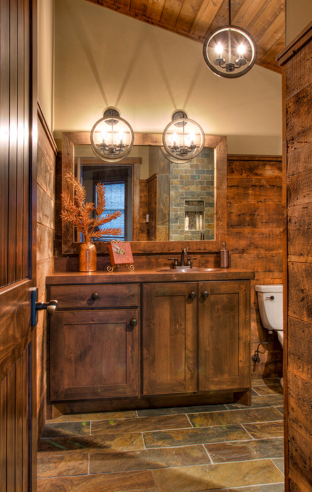 Inspiration for a mid-sized rustic master slate tile slate floor and multicolored floor bathroom remodel in Minneapolis with flat-panel cabinets, black cabinets, beige walls, a drop-in sink, wood countertops and brown countertops