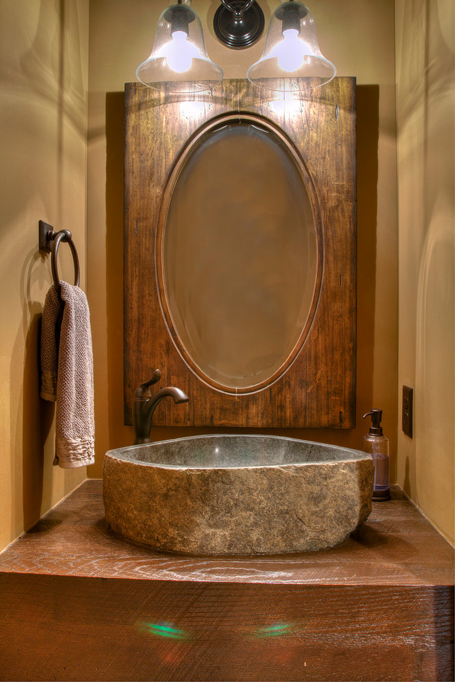 Inspiration för mellanstora rustika brunt en-suite badrum, med släta luckor, bruna skåp, beige väggar, ett fristående handfat och träbänkskiva