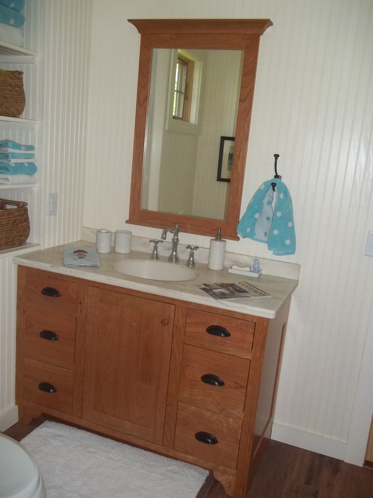 Inspiration pour une salle de bain rustique en bois clair de taille moyenne pour enfant avec un placard à porte shaker, un plan de toilette en surface solide, un mur blanc et un sol en bois brun.