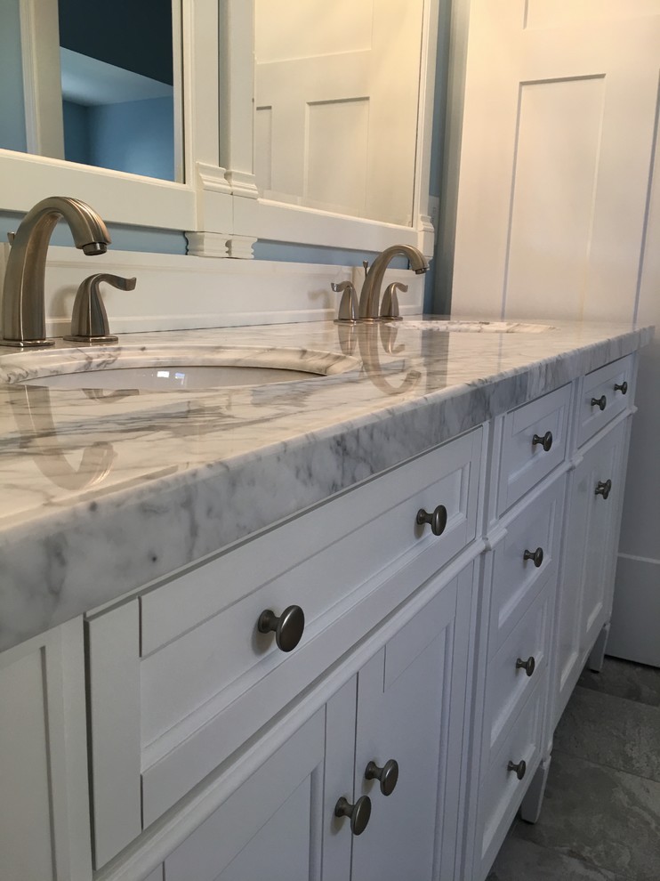 Photo of a medium sized classic ensuite bathroom in DC Metro with freestanding cabinets, white cabinets, a corner shower, grey tiles, porcelain tiles, blue walls, porcelain flooring, a submerged sink, quartz worktops, grey floors and a hinged door.