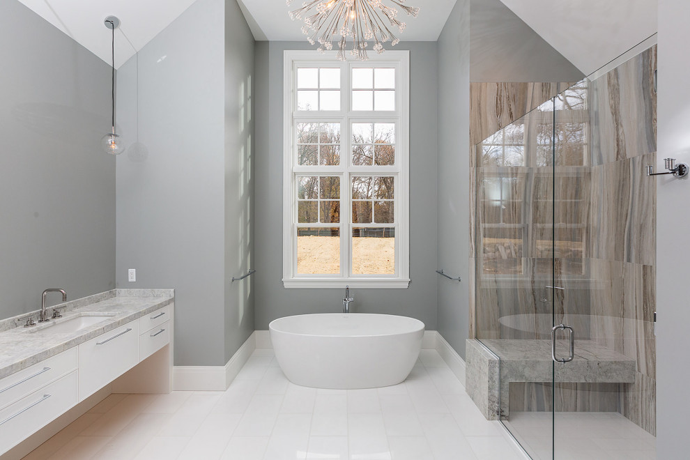 Immagine di un'ampia stanza da bagno padronale classica con ante lisce, ante bianche, vasca freestanding, lavabo sottopiano, top in marmo e top beige