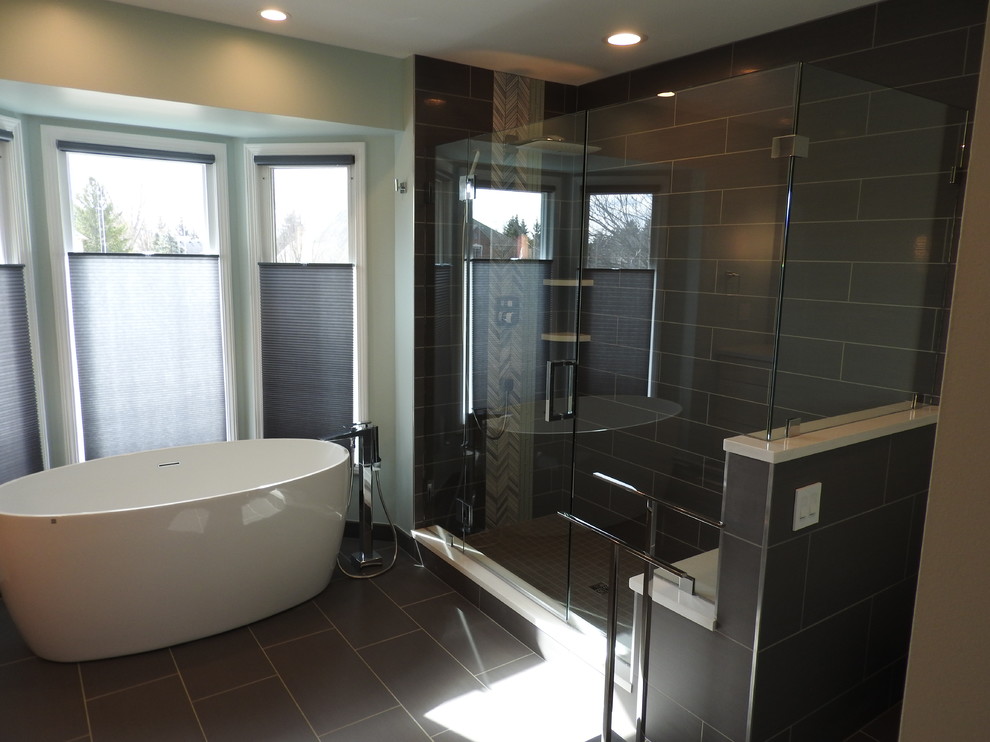 Exempel på ett stort modernt en-suite badrum, med släta luckor, skåp i ljust trä, ett fristående badkar, en hörndusch, en toalettstol med hel cisternkåpa, grå kakel, porslinskakel, gröna väggar, klinkergolv i porslin, ett undermonterad handfat och bänkskiva i kvarts