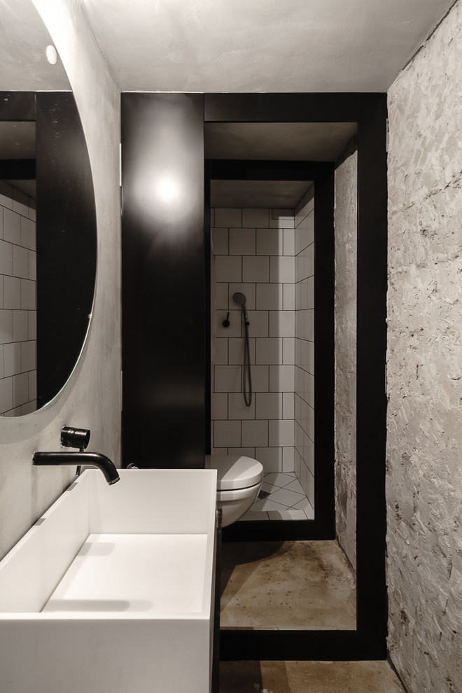 Идея дизайна: маленькая главная ванная комната в стиле лофт с плоскими фасадами, белыми фасадами, душем в нише, раздельным унитазом, белой плиткой, плиткой кабанчик, серыми стенами, бетонным полом, раковиной с несколькими смесителями, бежевым полом и открытым душем для на участке и в саду