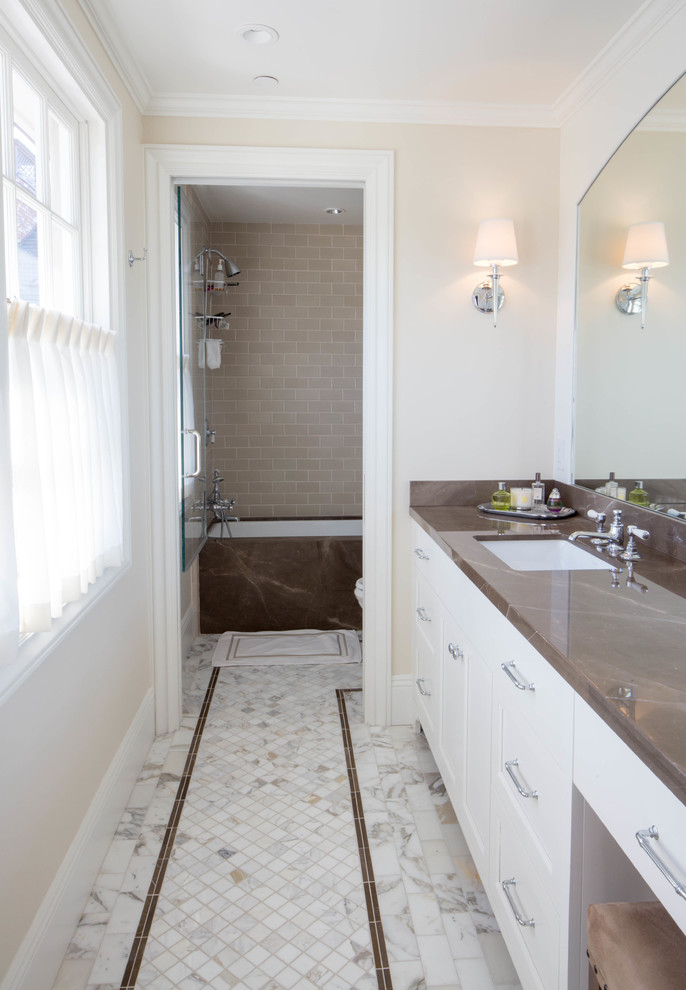 Small transitional kids' multicolored tile and marble tile marble floor tub/shower combo photo in San Diego with shaker cabinets, white cabinets, an undermount tub, a two-piece toilet, beige walls, an undermount sink and marble countertops