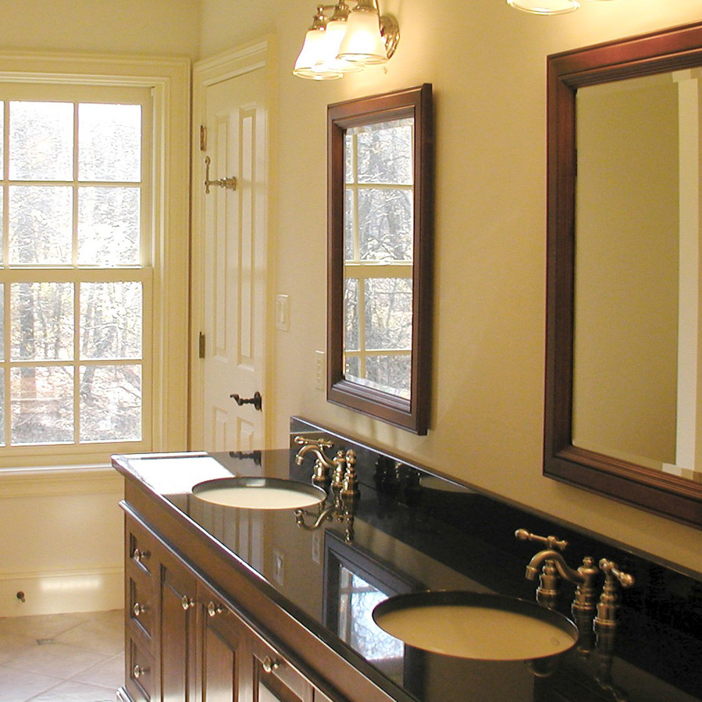 Esempio di una stanza da bagno classica con lavabo sottopiano, ante con riquadro incassato, ante in legno bruno, top in granito, pareti bianche e pavimento con piastrelle in ceramica