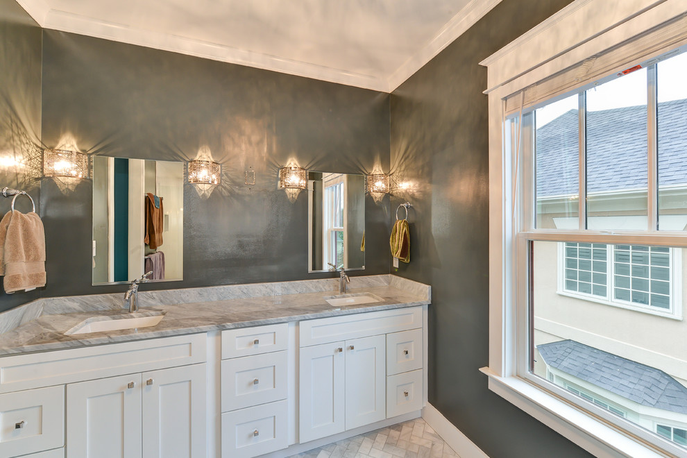 Amerikansk inredning av ett stort en-suite badrum, med ett undermonterad handfat, luckor med infälld panel, vita skåp, granitbänkskiva, en dusch i en alkov, en toalettstol med separat cisternkåpa, vit kakel, keramikplattor, gröna väggar och klinkergolv i keramik