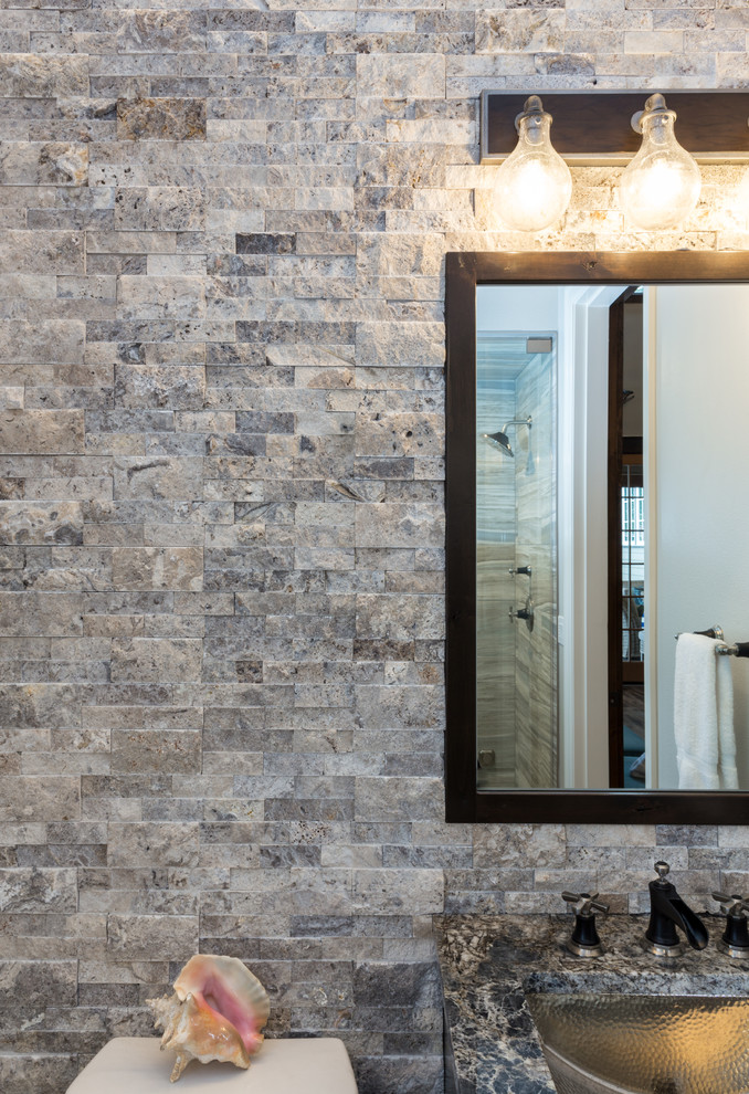 Mid-sized mountain style 3/4 gray tile and stone slab alcove shower photo in Portland with brown cabinets, a two-piece toilet, gray walls, a drop-in sink, quartzite countertops, a hinged shower door and brown countertops