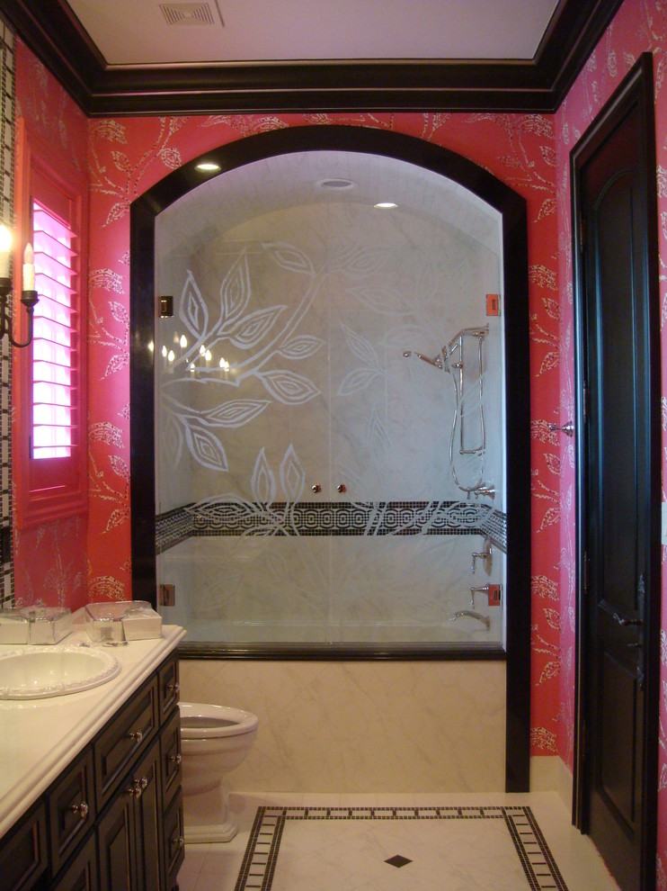 Cette photo montre une salle de bain éclectique en bois foncé de taille moyenne pour enfant avec un placard avec porte à panneau surélevé, un plan de toilette en marbre, une baignoire posée, un carrelage gris, des carreaux de porcelaine, un mur rose et un sol en carrelage de porcelaine.