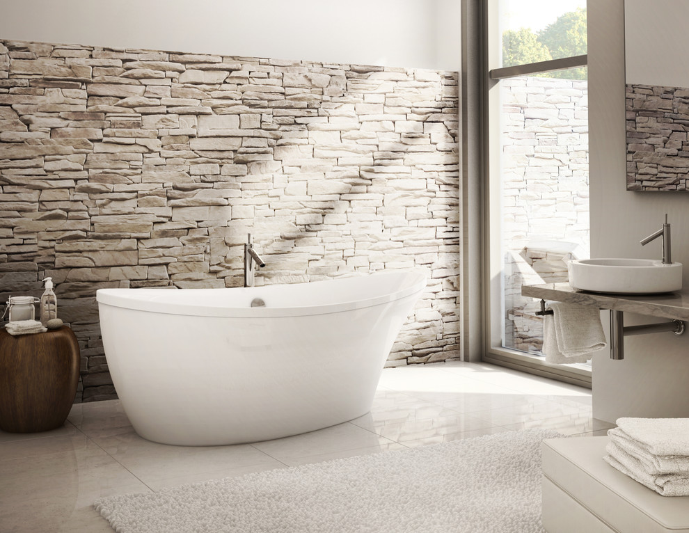 Modern inredning av ett stort en-suite badrum, med ett fristående badkar, grå väggar, klinkergolv i porslin, ett fristående handfat och granitbänkskiva