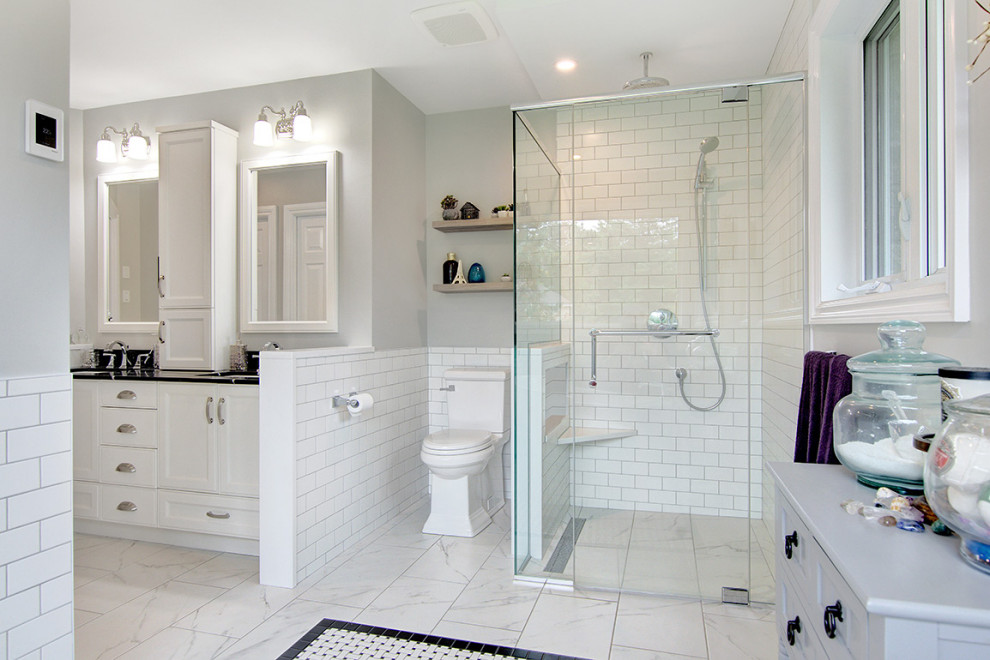 Inspiration for a large timeless master white tile and porcelain tile porcelain tile and white floor bathroom remodel in Ottawa with recessed-panel cabinets, white cabinets, a one-piece toilet, gray walls, an undermount sink, quartz countertops, a hinged shower door and black countertops