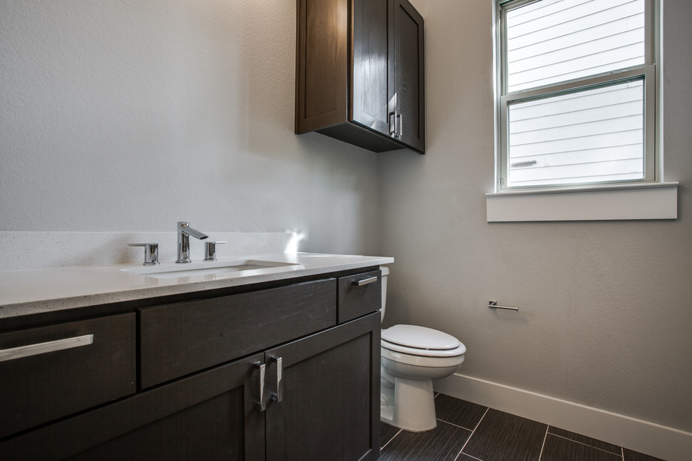 Immagine di una stanza da bagno con doccia minimalista di medie dimensioni con ante in stile shaker, ante in legno bruno, top in quarzo composito, WC a due pezzi, piastrelle marroni e pareti grigie