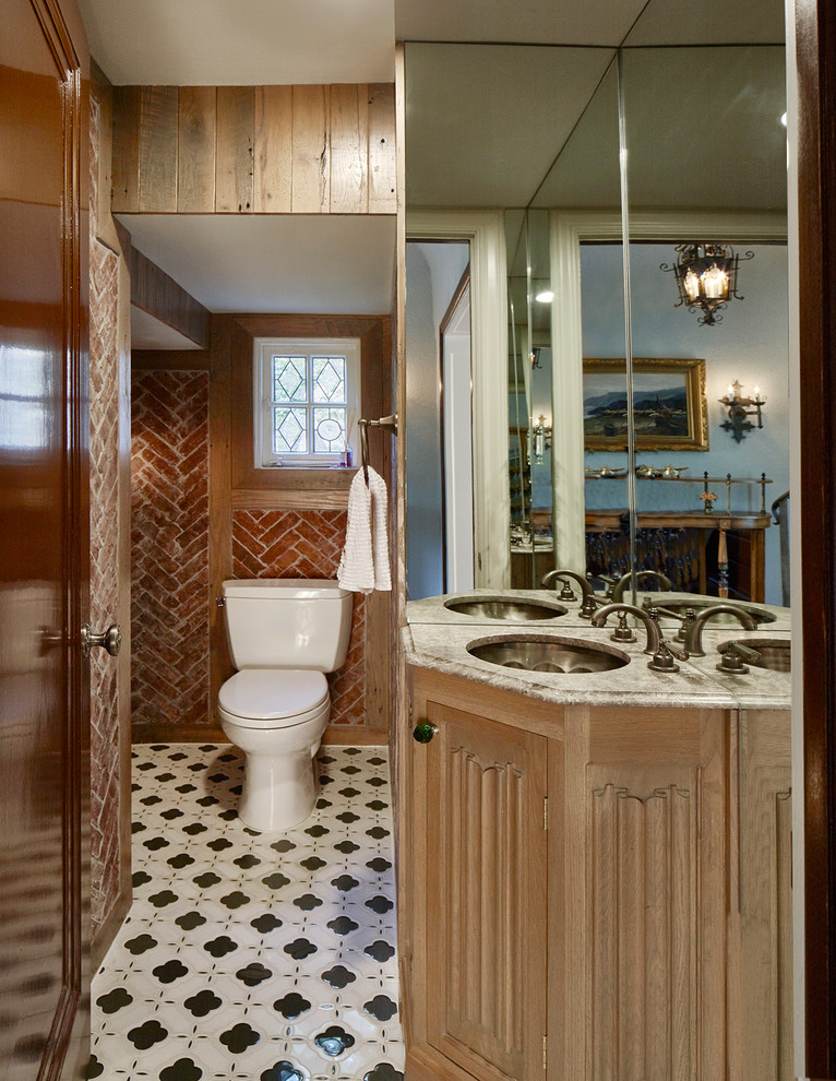 Example of a mid-sized classic 3/4 beige tile white floor bathroom design with shaker cabinets, brown cabinets, a one-piece toilet, orange walls, an undermount sink and white countertops