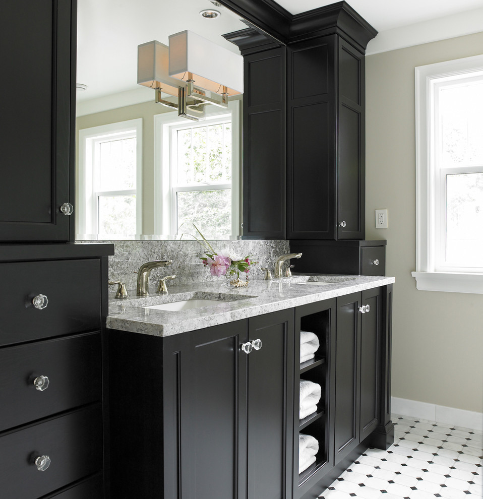 Idée de décoration pour une salle de bain tradition avec un lavabo encastré, un placard avec porte à panneau encastré, des portes de placard noires et un carrelage blanc.