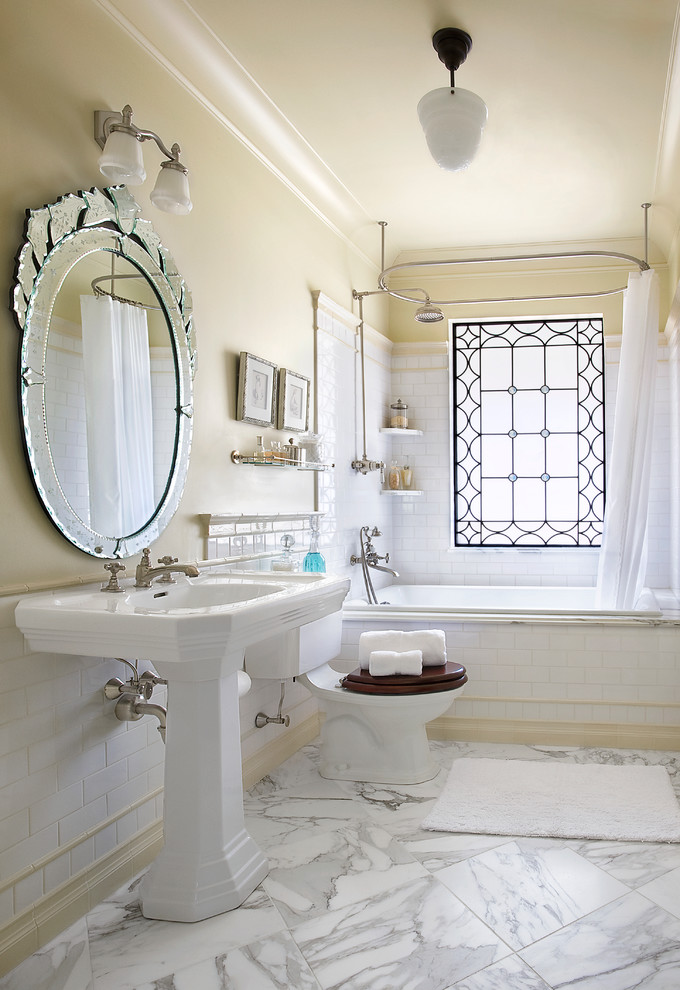 Inspiration för ett vintage en-suite badrum, med ett piedestal handfat, ett platsbyggt badkar, vit kakel, en dusch/badkar-kombination, en toalettstol med separat cisternkåpa, marmorbänkskiva, dusch med duschdraperi, tunnelbanekakel, beige väggar, marmorgolv och vitt golv