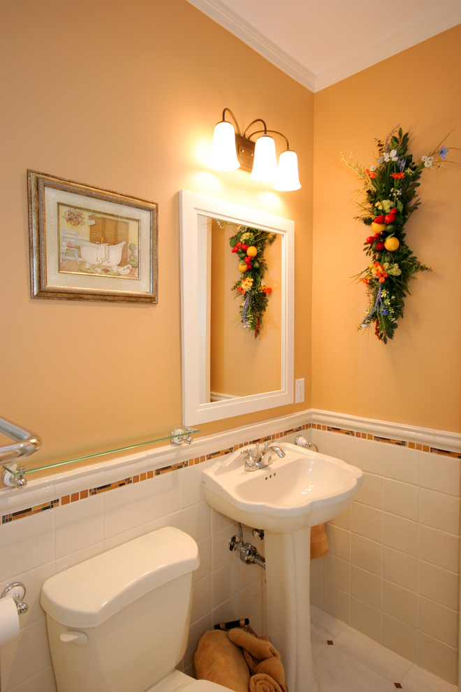 Immagine di una stanza da bagno tradizionale di medie dimensioni con lavabo a colonna, WC a due pezzi, piastrelle multicolore, piastrelle in ceramica, pareti gialle e pavimento in marmo